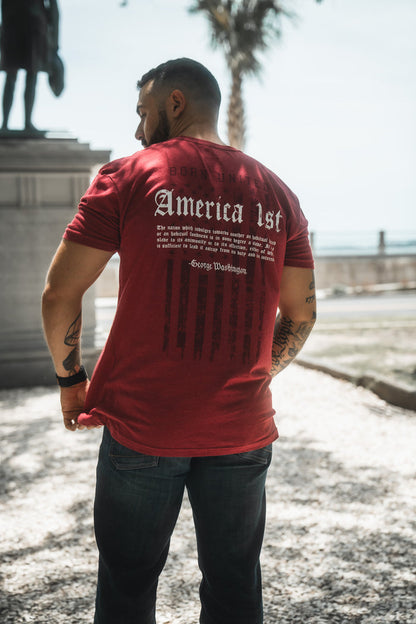 Man wearing a red t-shirt with text on the back, standing outdoors.