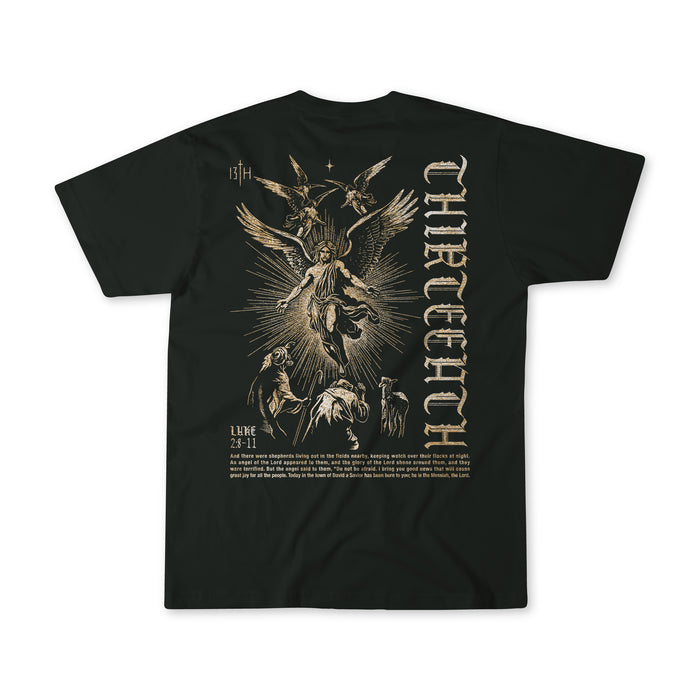 The 13th "The Messenger" black t-shirt features a vintage gold angel illustration with people and animals, gothic THIRTEEN text printed vertically on the right, and LUKE 2:7-11 plus more text below the image.