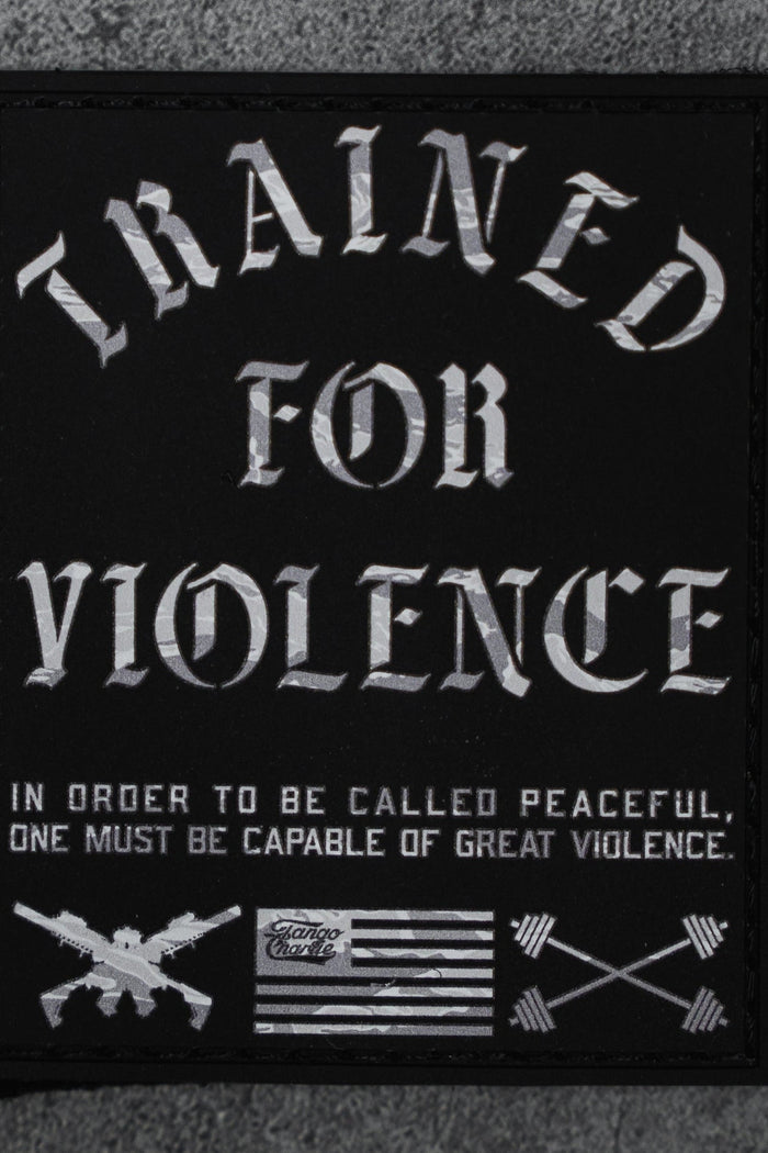 The Trained For Violence - Patch by Tango Charlie Apparel is a 3" black Velcro patch featuring bold white "TRAINED FOR VIOLENCE" text, crossed rifles, arrows, a black-and-white flag, and a striking 3D PVC design.